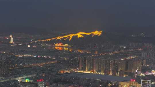 夜景中的城市与山上的龙灯光造型