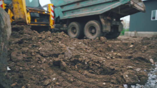 在农村的道路工程中，挖掘机臂舀起一桶土和石头视频素材模板下载
