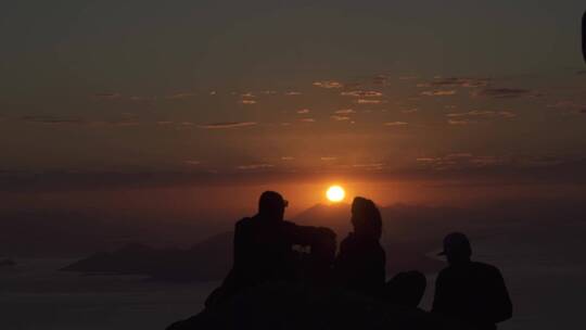 游客在山顶上拍摄日落景色