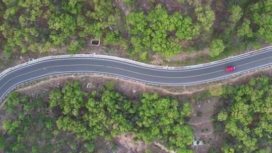 航拍跟随青翠山野公路上的一辆汽车