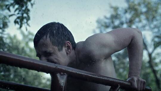 赤裸上身的男子在雨中锻炼