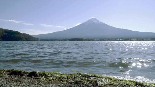 富士山与湖泊距离的低角度视图和海滩上的小波浪