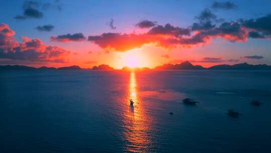 日落和岛屿背景下海上船只的剪影。海上风景