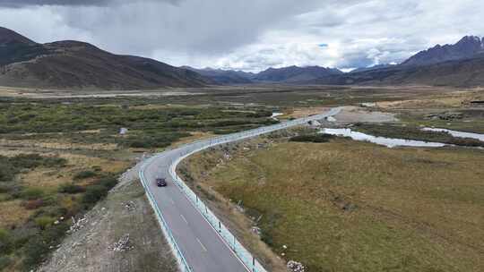 航拍汽车行驶在四川甘孜理塘措普沟户外道路