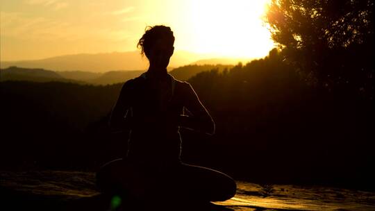 一名女子在日落时做瑜伽的剪影视频素材模板下载