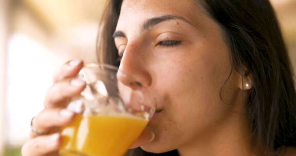 一个年轻黑发女人正在喝一种新鲜健康的饮食