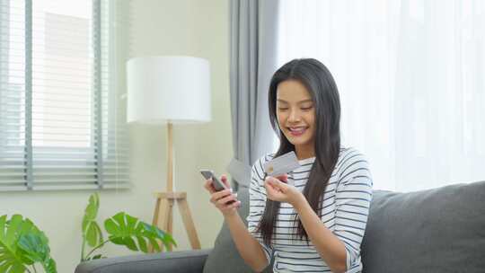 亚洲有魅力的女人喜欢在家里的客厅里网上购物。