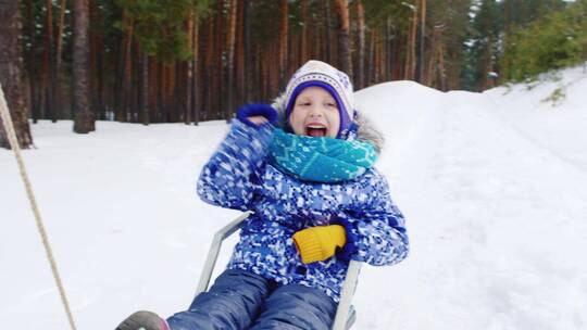小孩坐在雪橇上