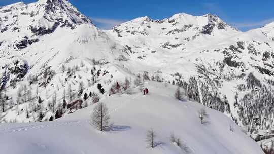 一组滑雪旅游在皮肤上坡排成一行。在大山里滑雪旅游