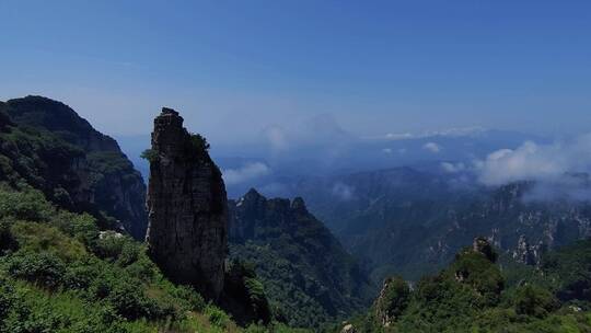 登山爱好者站在山巅，俯视群山