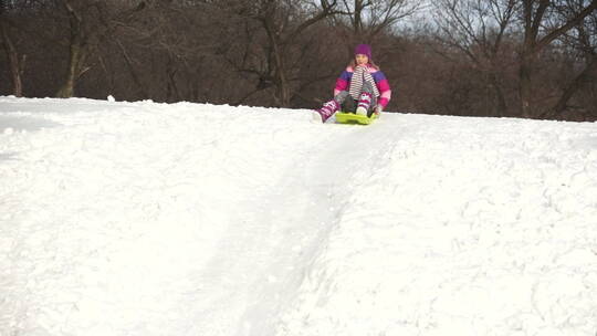 女孩坐着滑雪板滑下雪山