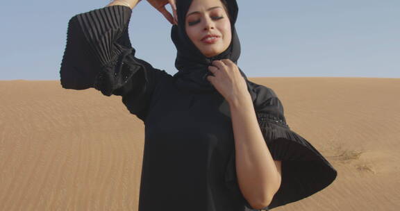 在多风的沙漠中摆姿势的女人