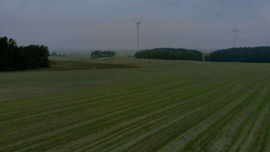 风力发电场雾蒙蒙的早晨，风车在田野里靠得很近，