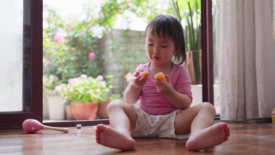 可爱的亚洲小女孩在家里玩耍分享食物