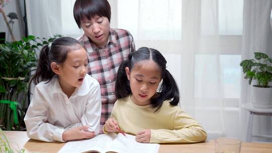 辅导两个孩子写作业的母亲视频素材模板下载
