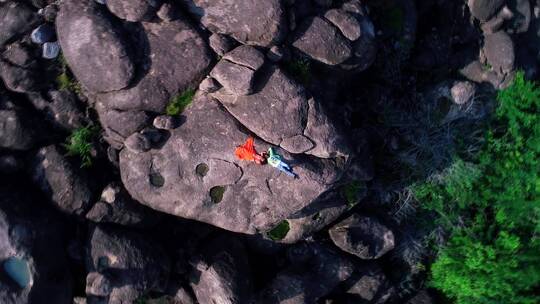 夫妇躺在悬崖上的航拍镜头