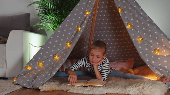女孩在室内帐篷看书