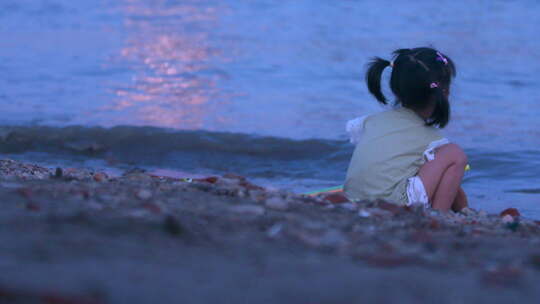 武汉武昌江滩傍晚夕阳余晖下玩水的小女孩