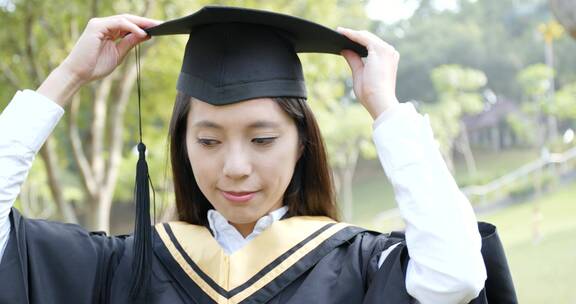 女生微笑着整理毕业礼帽