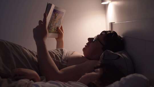 成人晚上和孩子在床上看书