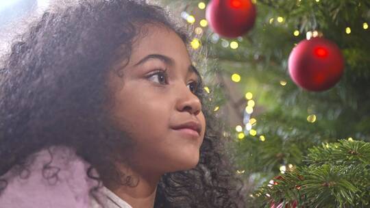 小女孩看着圣诞树微笑