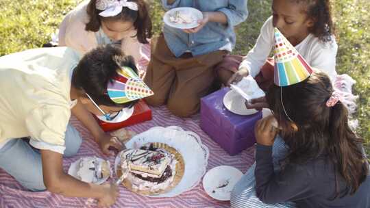 小孩子在公园里吃生日蛋糕