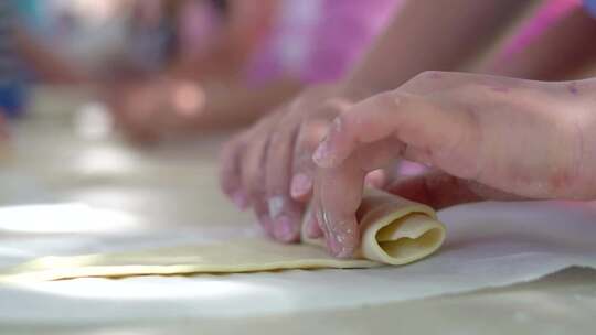 烹饪课。孩子们在学校做面包面团。慢动作中