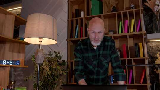 积极的中年男性企业家在家庭办公室的笔记本