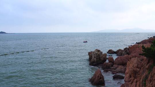 实拍青岛海岸线晚霞海水礁石与游客乘船视频