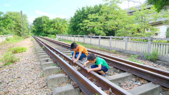 两个小孩在铁路上玩耍