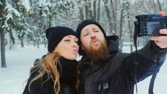 俏皮的年轻夫妇在雪地里自拍