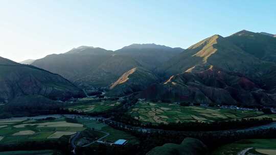 夕阳下山谷里的河流村庄田野航拍大景