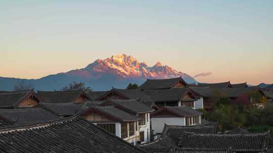 丽江古城屋顶和玉龙雪山日照金山延时摄影