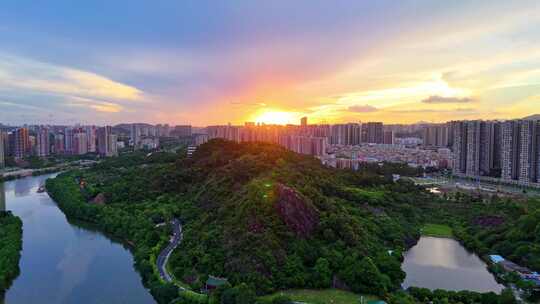 惠州大亚湾夕阳下的城市高楼与山林景观