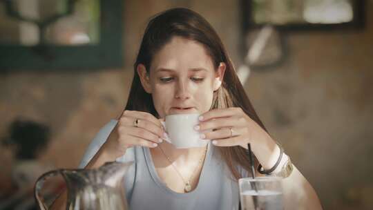 坐在桌旁的女人在咖啡馆喝咖啡