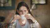 坐在桌旁的女人在咖啡馆喝咖啡高清在线视频素材下载