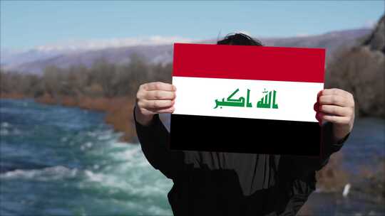 手持伊拉克国旗旗帜的人