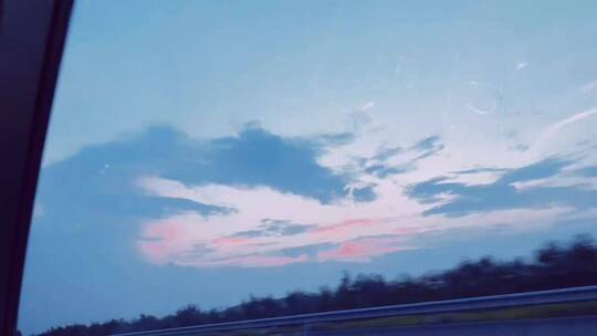 行驶的汽车路上夕阳蓝粉色夕阳天空