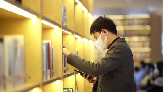 年轻男子在现代图书馆看书学习