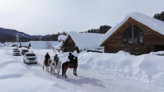 航拍新疆冬季游客在禾木村游玩雪景森林