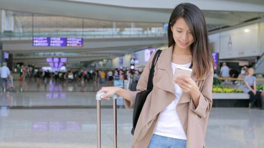 旅行妇女在机场使用手机