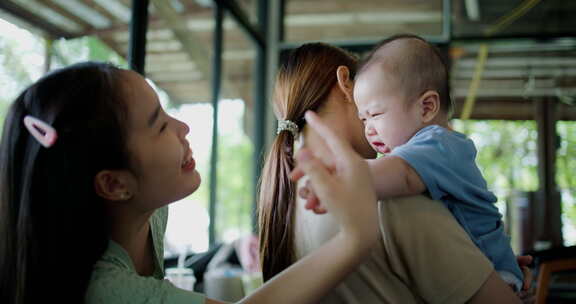 两个年轻的亚洲女人在咖啡馆里开心地和一个