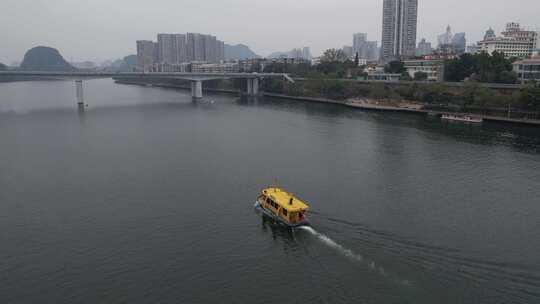 城市河流上行驶的黄色游船