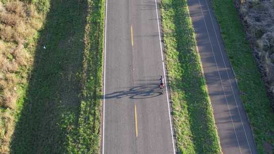 无人机跟随骑自行车的人沿着笔直的道路行驶