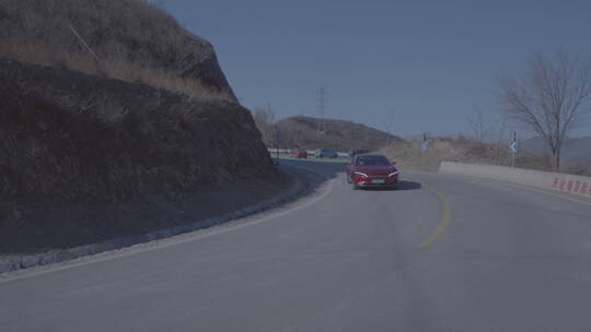 红色新能源电动汽车在山路 s弯道转弯 跟拍