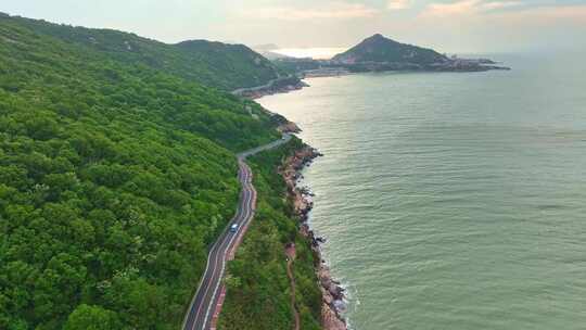 海岸边绿意盎然的山景与平静海面