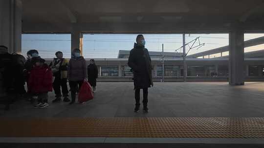 动车驶入高铁站与站台的旅客特写