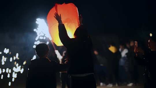 夜晚年轻人放孔明灯