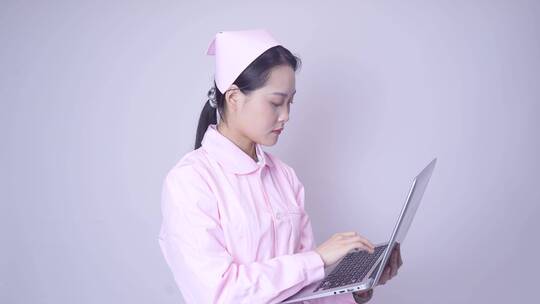 年轻女性医护形象手持笔记本电脑办公视频素材模板下载