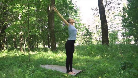 在树荫下练习瑜伽的女人